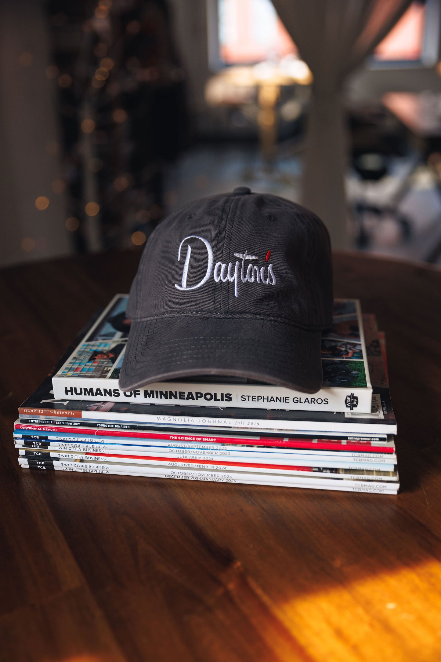 Black cap with 'Dayton' text on a stack of books on a wooden surface