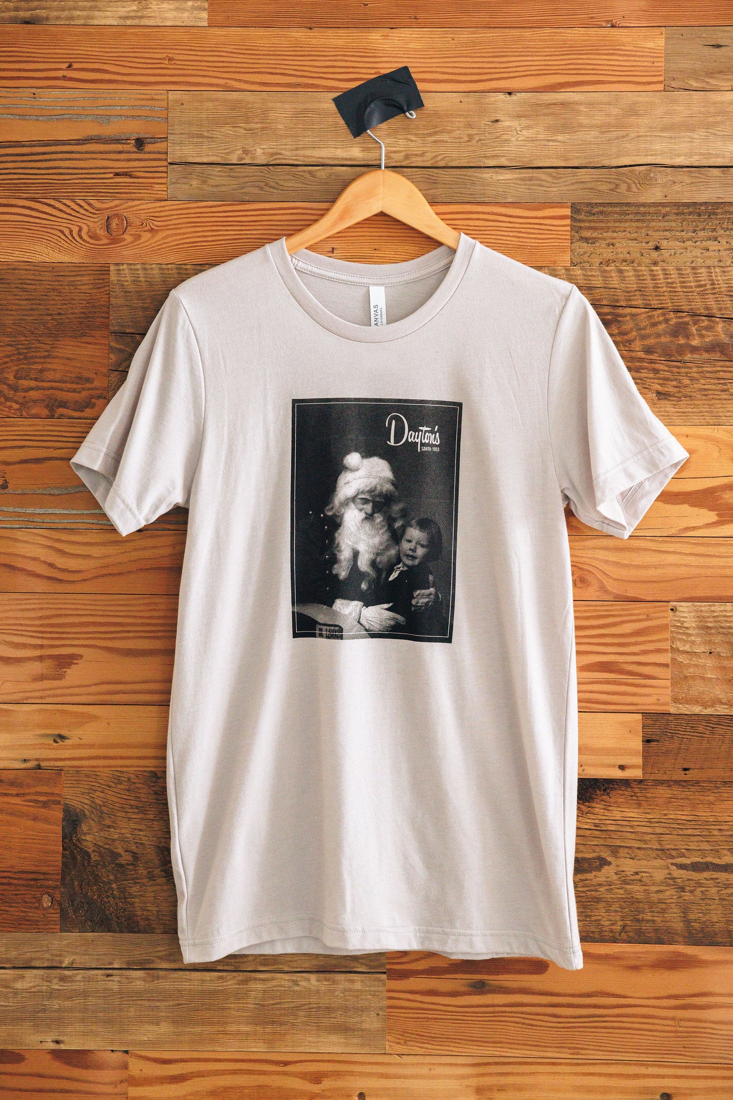 White t-shirt with a graphic design on a wooden wall