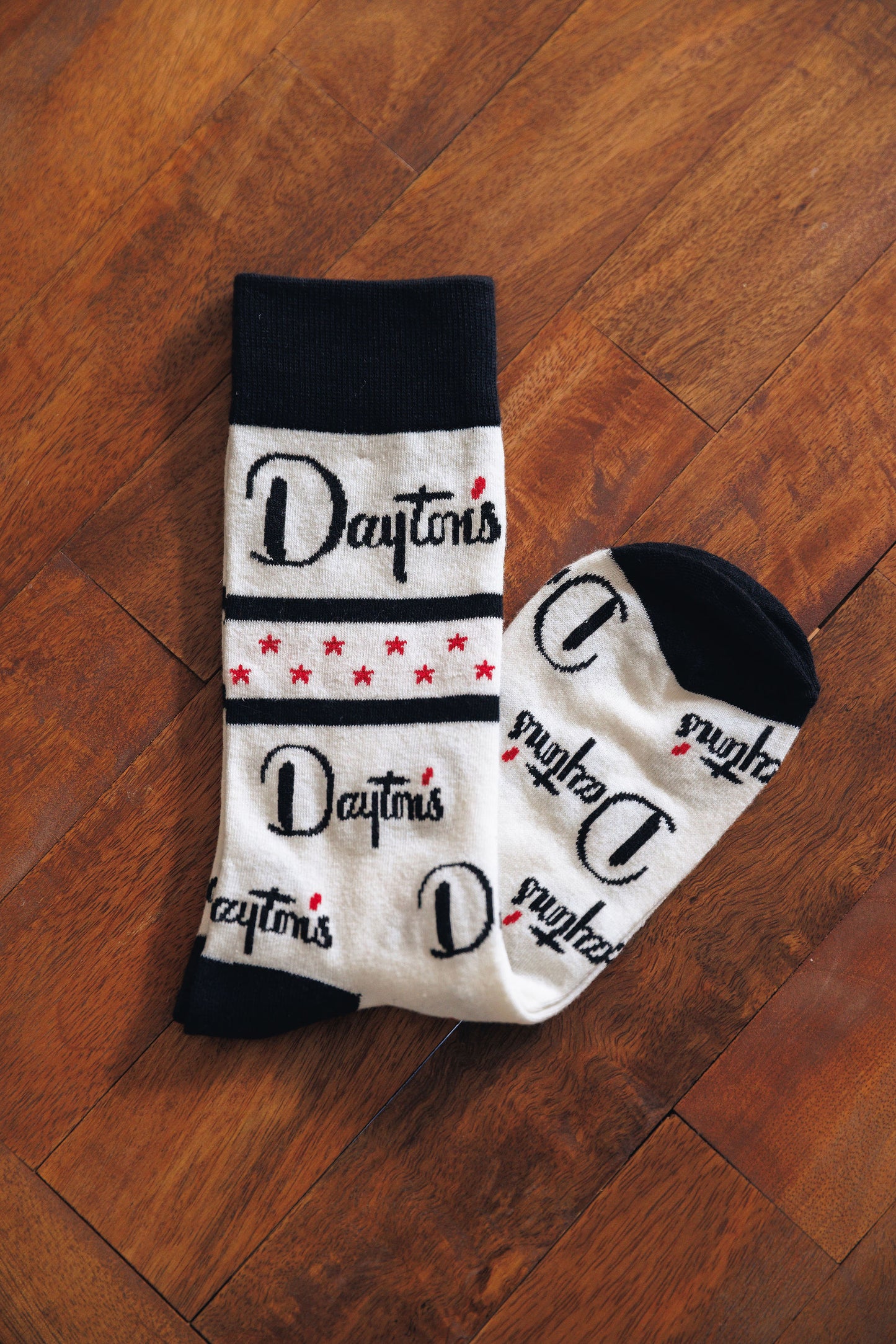 Pair of socks with 'Dayton's' branding on a wooden background.