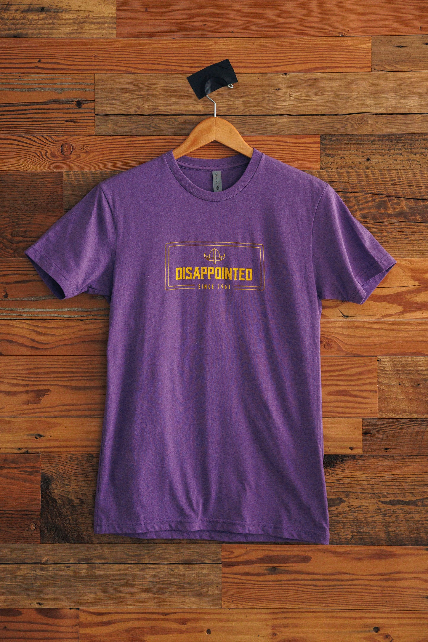 Purple t-shirt with text on a wooden background