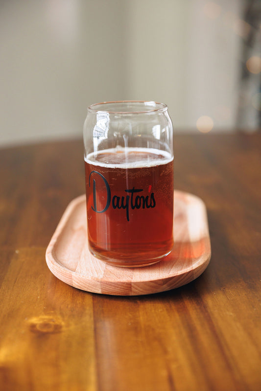 Glass of amber liquid with 'Dayton's' branding on a wooden coaster.