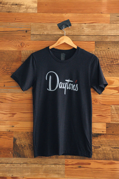 Black t-shirt with 'Dayton' logo on a wooden background