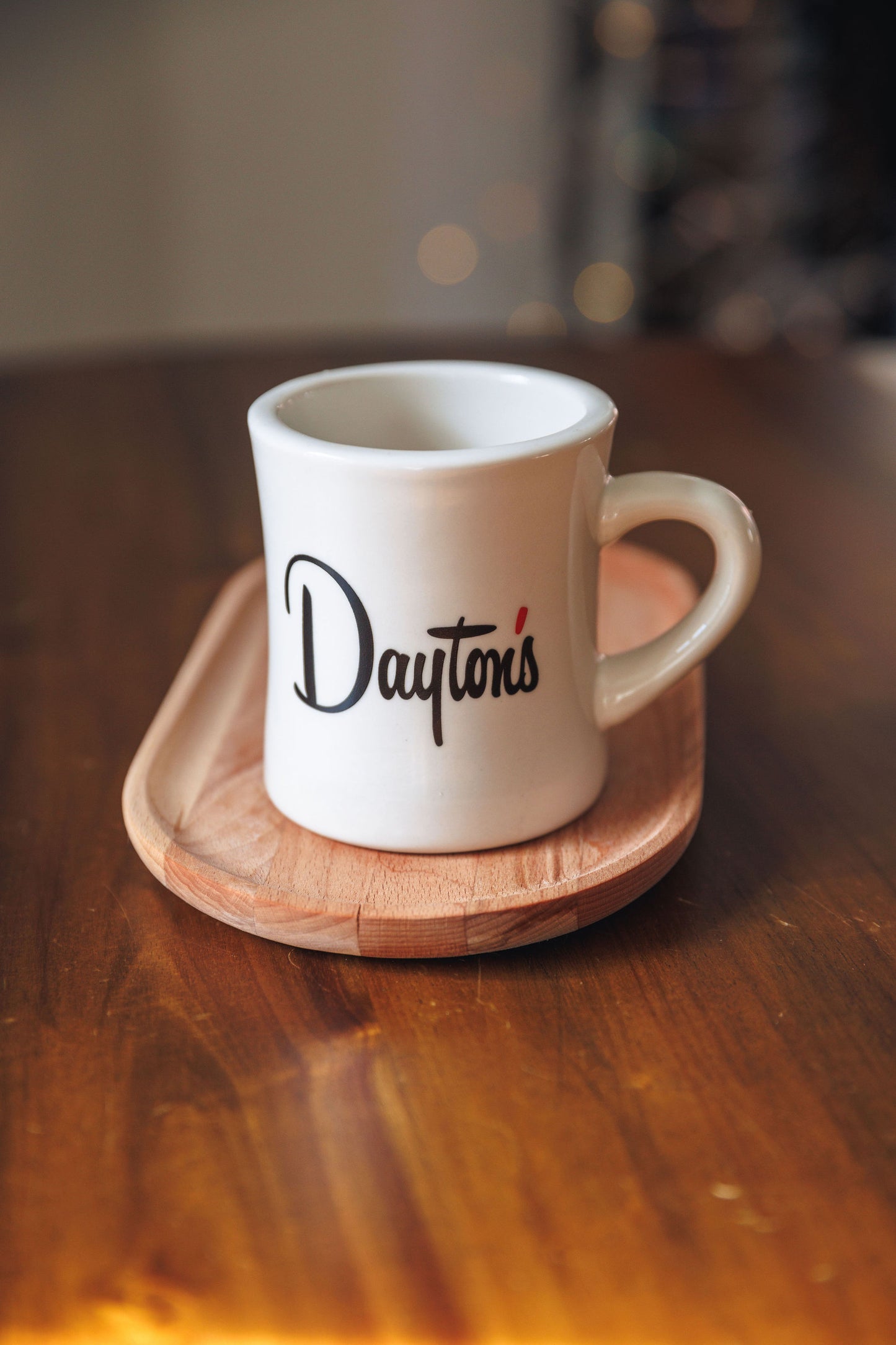 White mug with 'Dayton's' branding on a wooden coaster