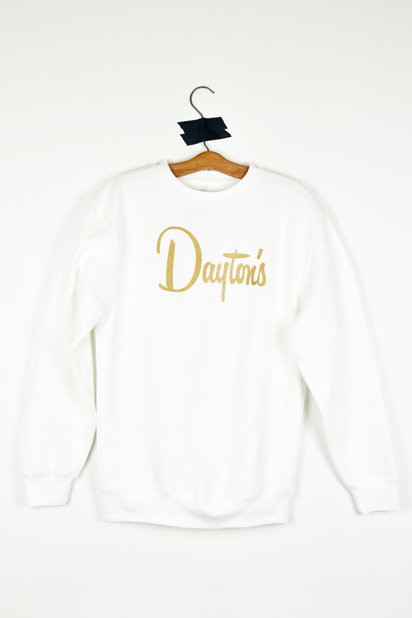 White sweatshirt with 'Dayton's' text on a hanger against a white background