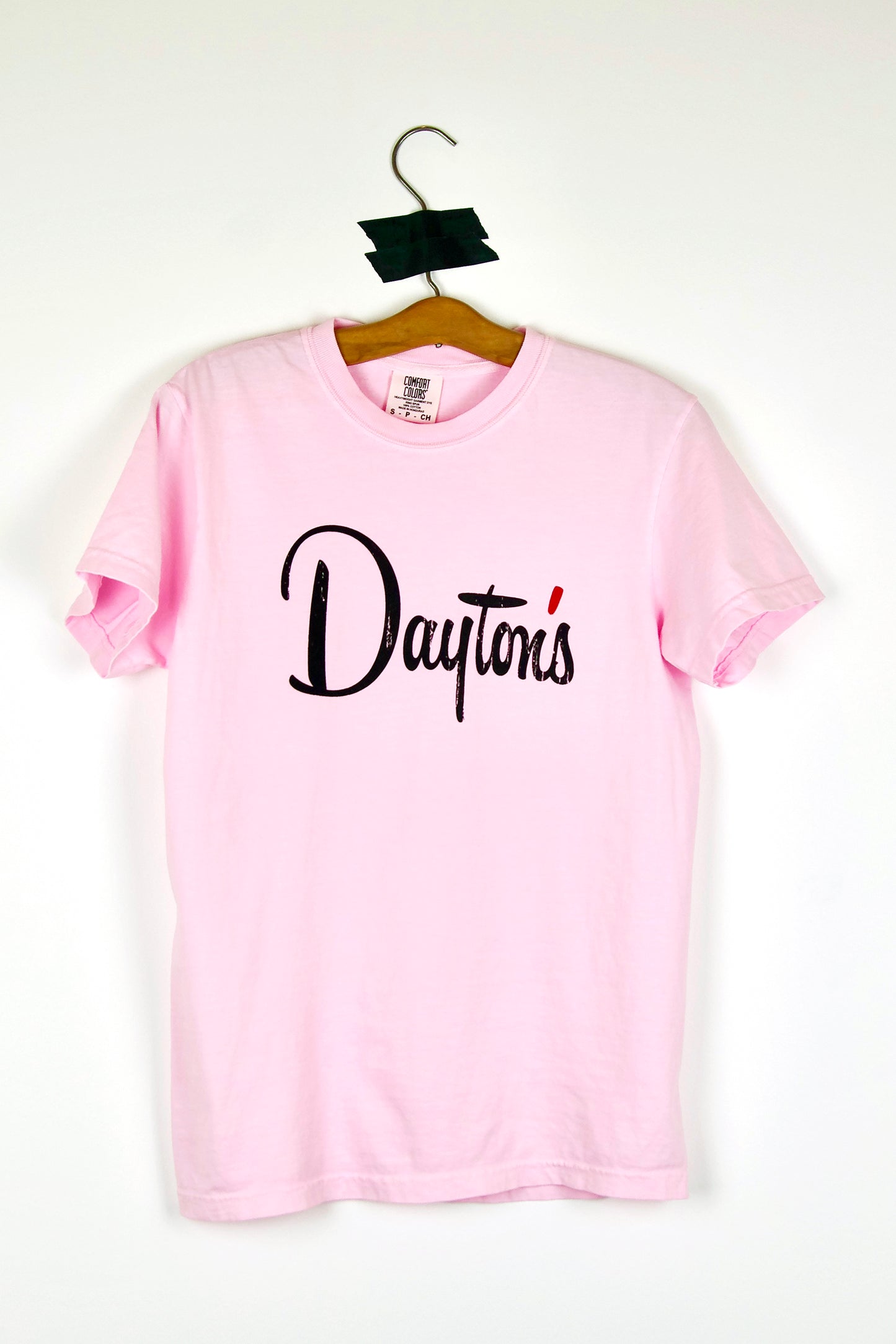 Pink t-shirt with 'Dayton's' text on a hanger against a white background