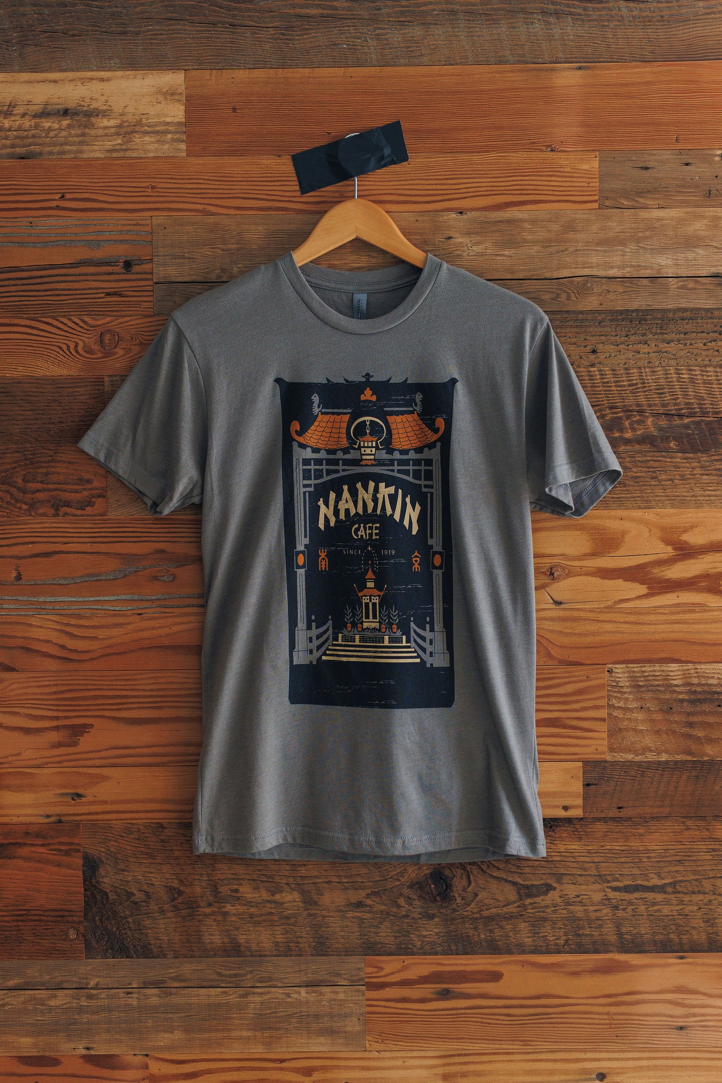 Gray t-shirt with a graphic design on a wooden background