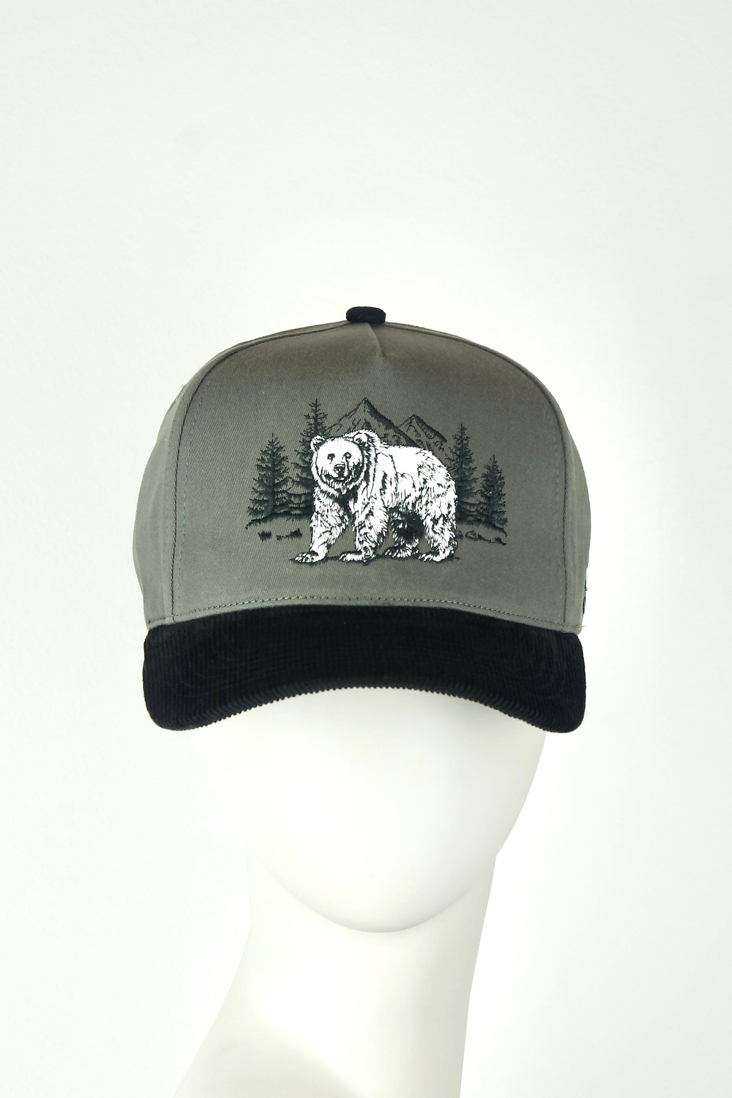 Gray cap with black brim featuring a bear and forest design on a white background