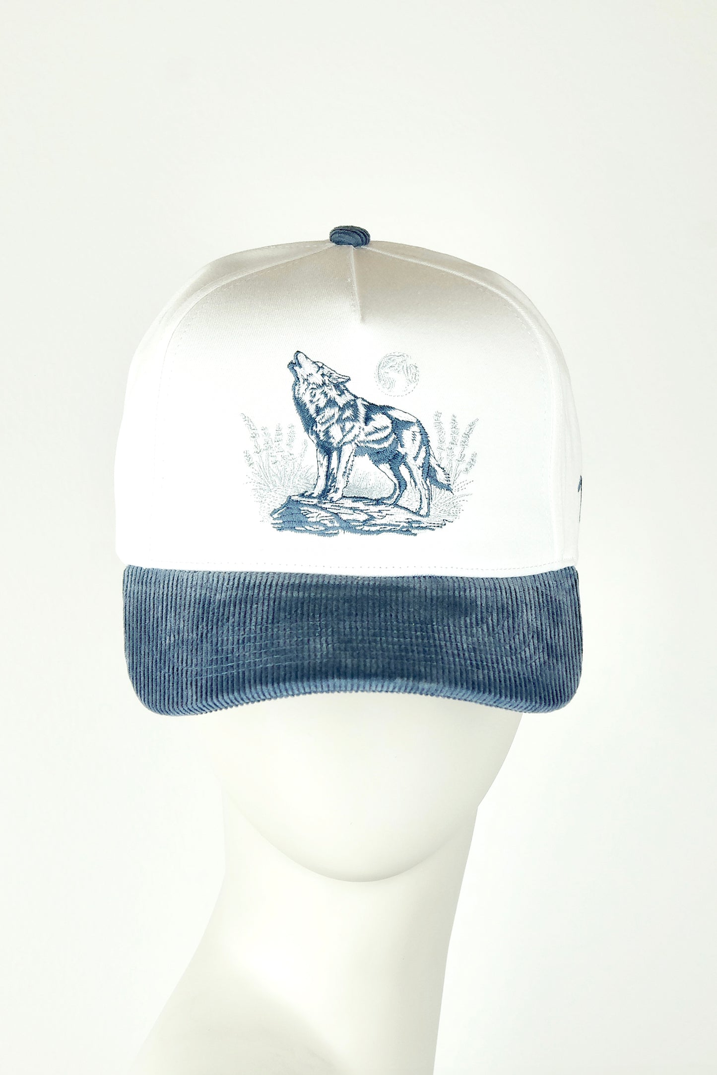 Cap with wolf design on a mannequin head against a white background